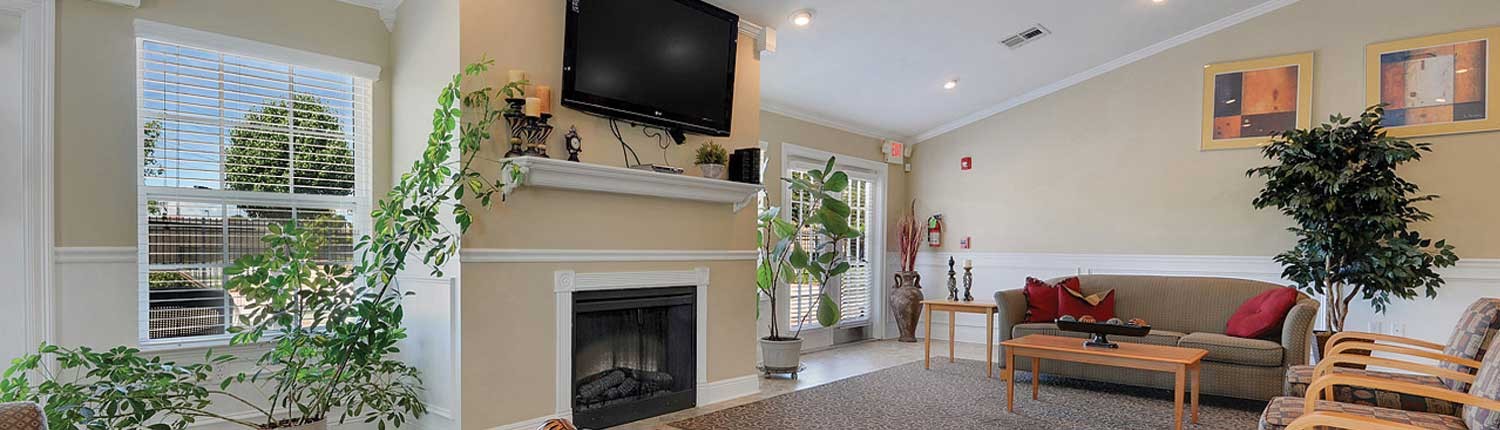 Clubhouse with a Tv, fireplace, couch, and coffee table at Canterbury house apartments in Baton Rouge